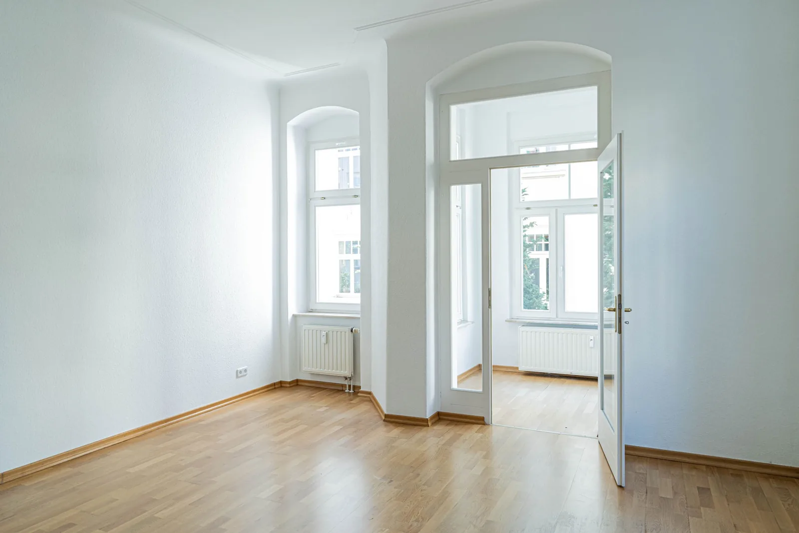 Leergeräumtes Altbauzimmer mit Parkett und Flügeltür